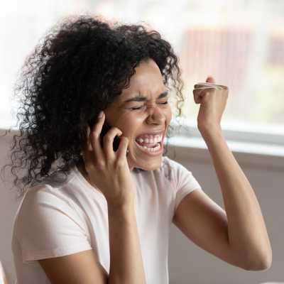 Beim Blog-Artikel "Die Macht der Gedanken" sieht man hier eine junge Frau telefonieren, die sich über ein Erfolgserlebnis freut